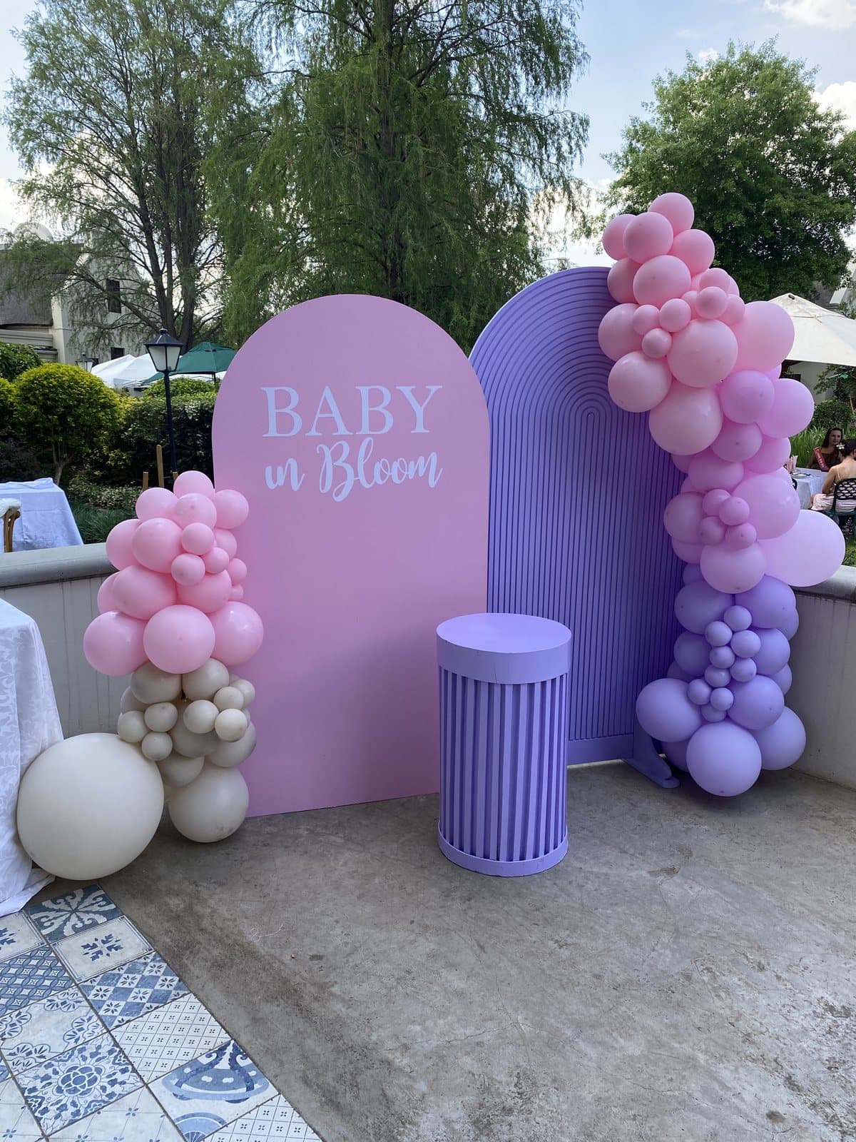 Lavender and pink balloon arch with a Baby in Bloom sign for a baby shower