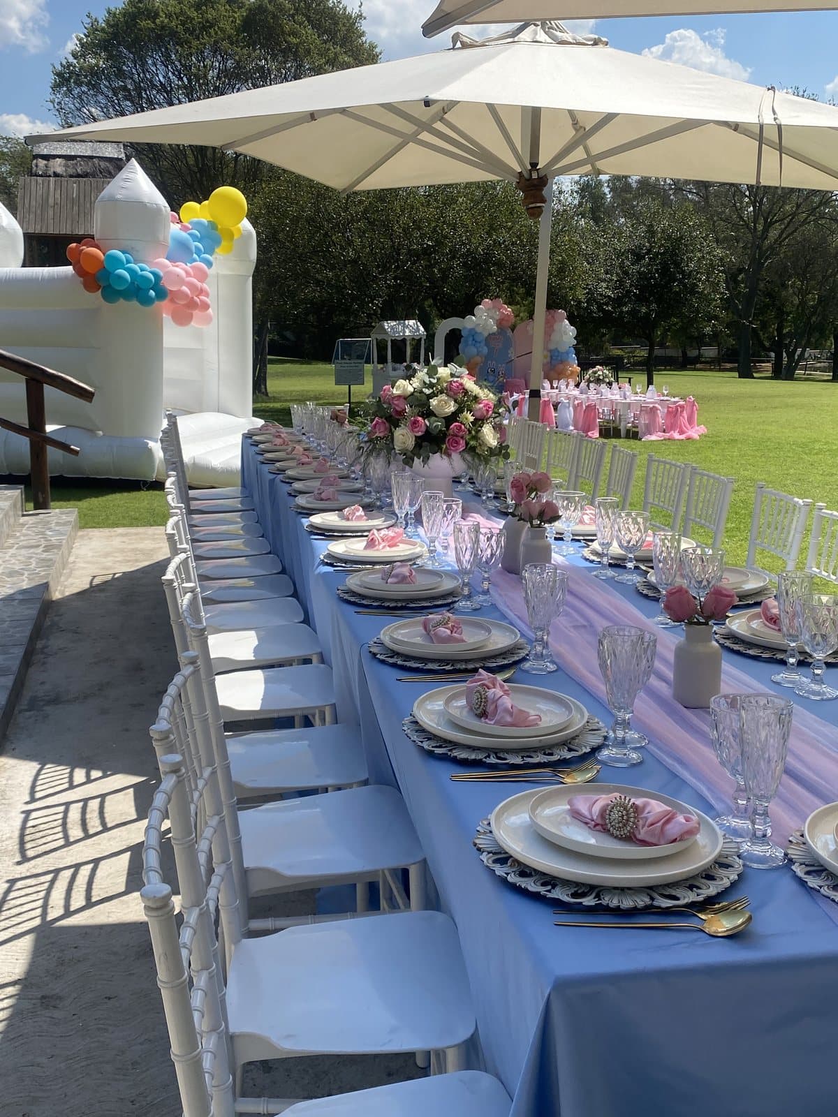 Elegant outdoor table setting in blue and white under umbrellas