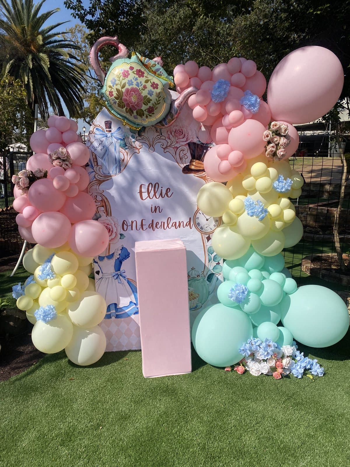 Pastel yellow, blue and mint floral balloon arch for a birthday celebration