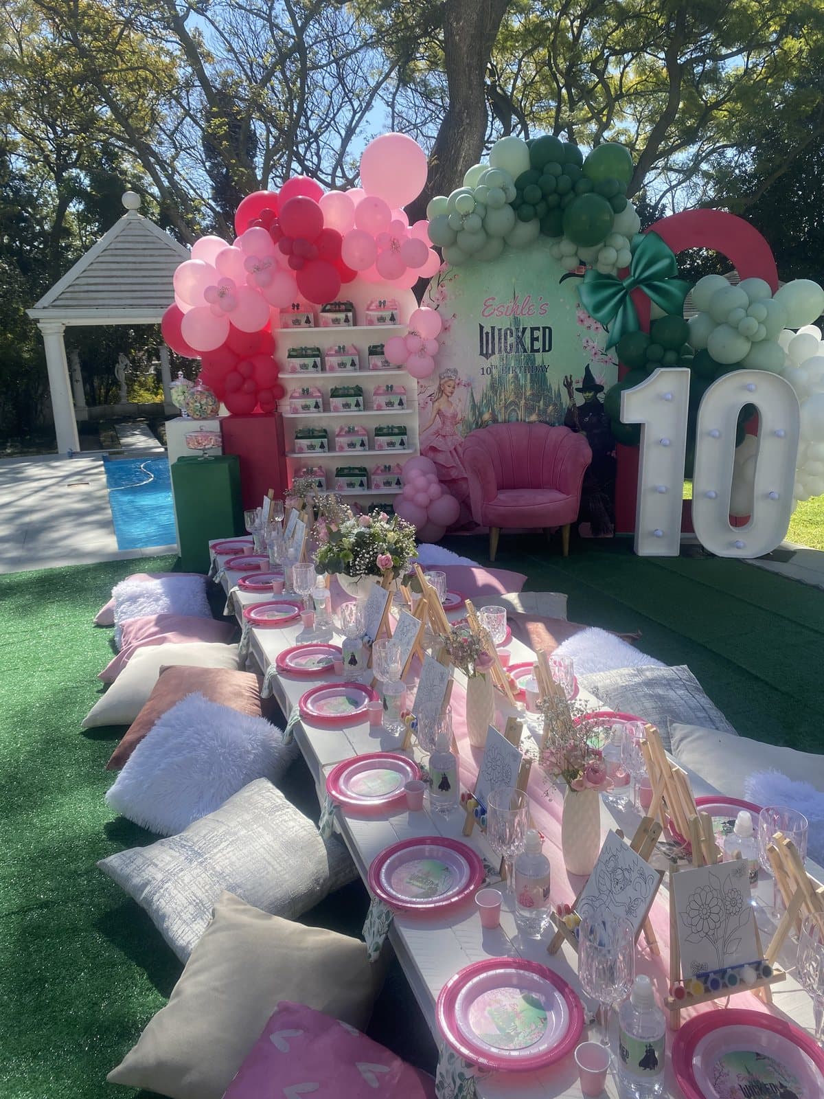 Green and pink balloon arch with a pastel picnic table for a tenth birthday