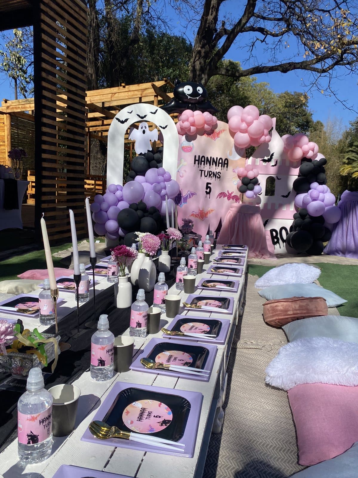 Pastel balloon arch with photo cutouts for a fifth birthday party