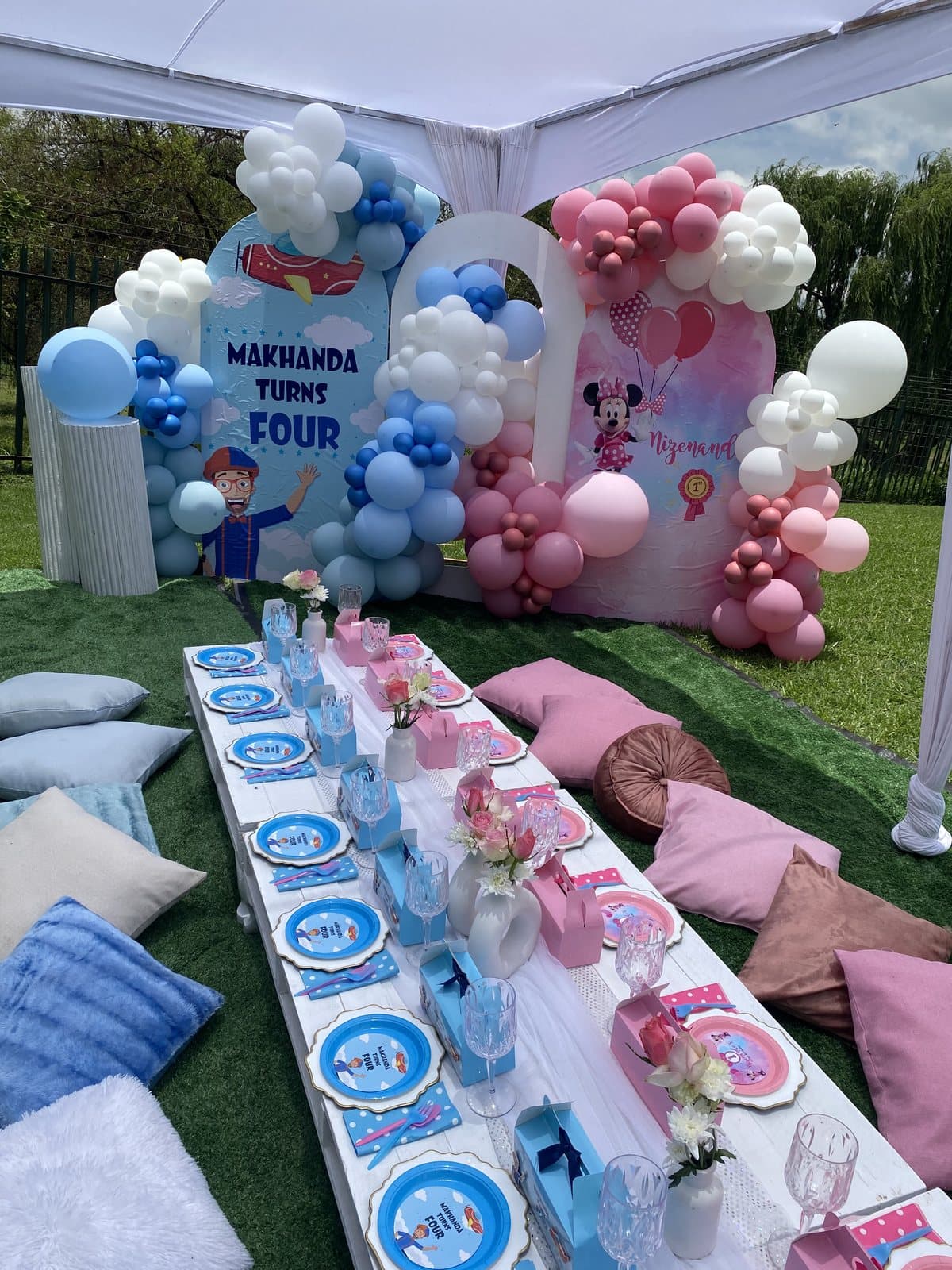 Pink and blue balloon arch with a pastel picnic table for a fourth birthday