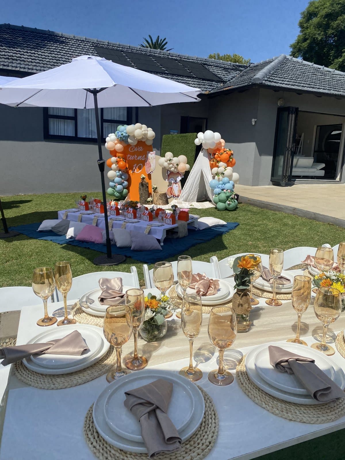 Orange and white safari themed balloon columns with boho table styling