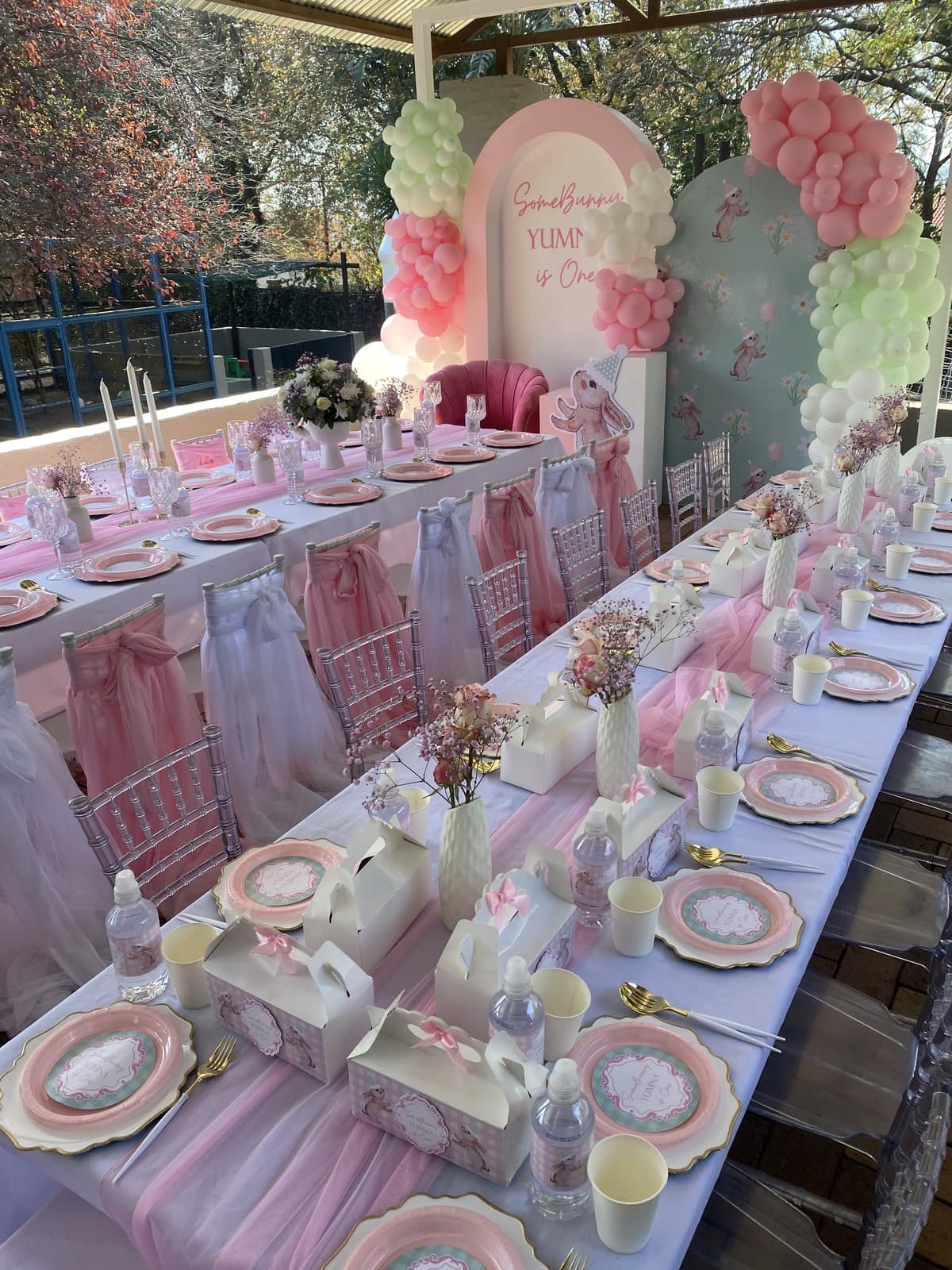 Long pink tablescape with chiavari chairs for a first birthday party