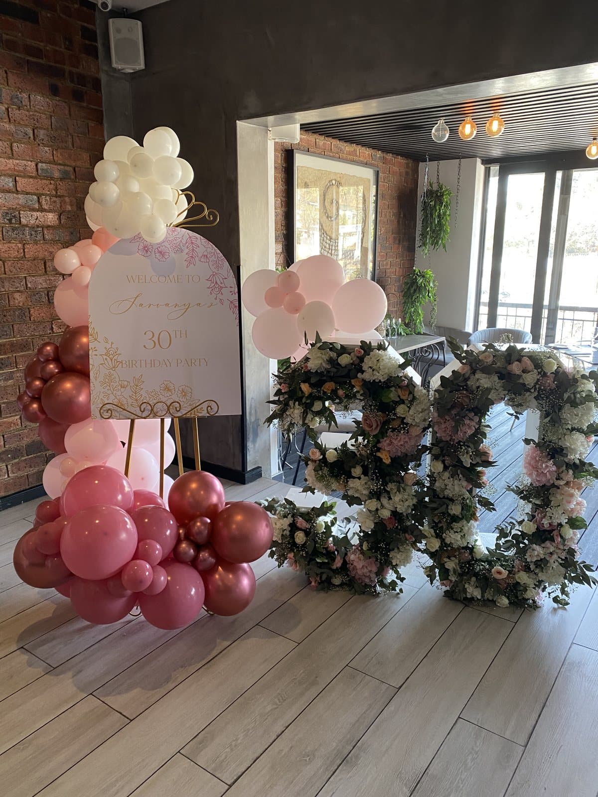 Floral wreath arrangements with a wine-toned balloon arch