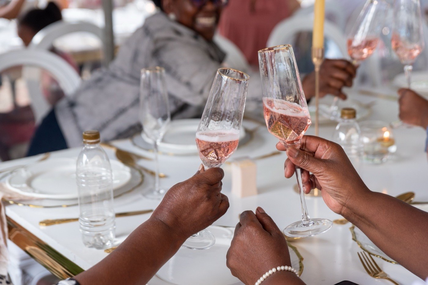 Guests raising sparkling wine glasses in a toast at an elegant reception